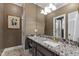 Bathroom features a marble countertop vanity, white trim and a large framed mirror at 7620 Rainwater Rd, Raleigh, NC 27615