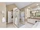 Bright bathroom featuring a glass enclosed shower, double vanity, and soaking tub with natural light at 7620 Rainwater Rd, Raleigh, NC 27615