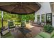 A beautiful wooden deck is shaded by an umbrella, featuring seating, a table, and backyard view at 7620 Rainwater Rd, Raleigh, NC 27615