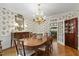 Elegant dining room with floral wallpaper, hardwood floors, and chandelier at 7620 Rainwater Rd, Raleigh, NC 27615