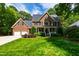 Charming brick home featuring a lush green lawn, two-car garage, and mature trees at 7620 Rainwater Rd, Raleigh, NC 27615