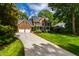 Elegant brick home boasting a spacious driveway, manicured lawn, and mature trees at 7620 Rainwater Rd, Raleigh, NC 27615