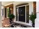 Elegant front door with decorative glass, black hardware, and potted ferns at 7620 Rainwater Rd, Raleigh, NC 27615