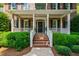 Inviting front porch with brick steps, white railings, and well-manicured shrubs at 7620 Rainwater Rd, Raleigh, NC 27615