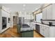 Well-equipped kitchen with stainless appliances, island with cooktop, and a farmhouse sink at 7620 Rainwater Rd, Raleigh, NC 27615