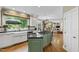 Bright kitchen with island cooktop, farmhouse sink beneath large window, and open to living area at 7620 Rainwater Rd, Raleigh, NC 27615