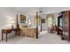 Spacious main bedroom with a four-poster bed, sitting area, carpet, and neutral tones at 7620 Rainwater Rd, Raleigh, NC 27615