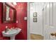 Stylish powder room with red wallpaper and elegant fixtures at 7620 Rainwater Rd, Raleigh, NC 27615