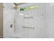 Modern shower with white marble tiles, gold fixtures, and window for natural light at 7620 Rainwater Rd, Raleigh, NC 27615