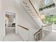 Bright staircase featuring white railings, hardwood, chandelier, and an abundance of natural light from large windows at 7620 Rainwater Rd, Raleigh, NC 27615