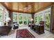 Bright sunroom with wood ceiling, tile flooring, and views of the landscaped yard at 7620 Rainwater Rd, Raleigh, NC 27615