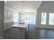 Well-lit kitchen with an island, pendant lighting, and a view of the wainscotted dining area and large windows at 776 Shadetree Rd, Benson, NC 27504