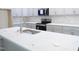 Close-up of kitchen island featuring a quartz countertop, modern sink, and stainless-steel appliances at 776 Shadetree Rd, Benson, NC 27504