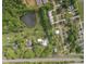 Aerial view features lush greenery, a pond, neighboring properties, railroad tracks, and a water tower at 7920 E Washington St, Mebane, NC 27302