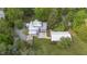 Backyard aerial view of a pristine lawn, trees, an open patio and covered seating at 7920 E Washington St, Mebane, NC 27302