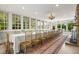 Elegant dining room featuring a long table, stone fireplace, and ample natural light at 7920 E Washington St, Mebane, NC 27302
