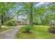 Residence featuring a lengthy driveway surrounded by mature trees and meticulously maintained landscaping at 7920 E Washington St, Mebane, NC 27302