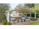 Open-air event space featuring a chandelier, garden setting, and ample seating for guests at 7920 E Washington St, Mebane, NC 27302