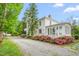Stunning white farmhouse with beautiful flower beds and gravel driveway at 7920 E Washington St, Mebane, NC 27302