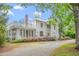 Sprawling home with a water tower features a columned facade, balcony, and meticulously manicured landscaping at 7920 E Washington St, Mebane, NC 27302