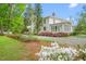 A home featuring a beautiful exterior with a manicured lawn and lush landscaping at 7920 E Washington St, Mebane, NC 27302