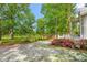 Lush front yard features a gravel driveway and vibrant azaleas, enhancing the home's curb appeal and natural beauty at 7920 E Washington St, Mebane, NC 27302