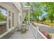 Covered porch with slate tile flooring, seating, and lovely landscaping at 7920 E Washington St, Mebane, NC 27302