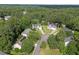 Aerial view of multiple houses in a heavily wooded neighborhood at 8 Summertime Ct, Durham, NC 27707