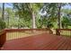 View of the wooden back deck overlooking the lush green backyard and mature trees at 8 Summertime Ct, Durham, NC 27707