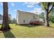 Backyard with a two-story house and a wooden deck surrounded by trees at 8 Summertime Ct, Durham, NC 27707