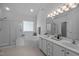 Bright bathroom with dual sinks, a glass-enclosed shower, and a garden tub at 8 Summertime Ct, Durham, NC 27707