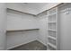 Walk-in closet with wooden shelving and rods for ample storage at 8 Summertime Ct, Durham, NC 27707