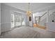 Bright dining room with large windows, chandelier, and view of the staircase at 8 Summertime Ct, Durham, NC 27707