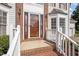 Welcoming entryway with beautiful wood door, sidelights, and classic white railings at 8 Summertime Ct, Durham, NC 27707