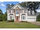 Charming two-story home boasts red shutters, a brick entryway, and an attached two-car garage at 8 Summertime Ct, Durham, NC 27707