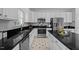 Modern kitchen with white cabinets, black countertops, stainless appliances, and center island at 8 Summertime Ct, Durham, NC 27707