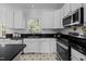 Modern kitchen featuring stainless steel appliances, granite countertops, and white cabinets at 8 Summertime Ct, Durham, NC 27707