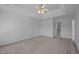 Carpeted primary bedroom featuring a tray ceiling with fan and access to the primary bathroom at 8 Summertime Ct, Durham, NC 27707