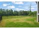 Large grassy backyard featuring a fence and view of the home's screened in back porch at 815 Laurelwood Dr, Durham, NC 27705