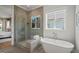 Bathroom featuring a glass shower, soaking tub, neutral color palette and natural light at 815 Laurelwood Dr, Durham, NC 27705