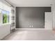Carpeted bedroom with a gray accent wall and bright window with curtains at 815 Laurelwood Dr, Durham, NC 27705