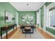 Stylish dining room featuring green walls, hardwood floors, a black wood table and elegant decor at 815 Laurelwood Dr, Durham, NC 27705