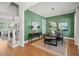 Dining area featuring hardwood floors, green walls, and a modern chandelier above the black wood table at 815 Laurelwood Dr, Durham, NC 27705