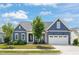 Charming single-Gathering home with a blue exterior, well-manicured lawn, and a two-car garage at 815 Laurelwood Dr, Durham, NC 27705