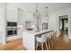 Bright kitchen with white cabinets, marble countertops, stainless steel appliances, and island seating at 815 Laurelwood Dr, Durham, NC 27705