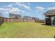 Large backyard with a well-maintained lawn, wooden fence, and a screened in porch at 1025 Quindell Dr, Holly Springs, NC 27540