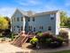Spacious backyard featuring a deck with stairs, brick patio, and beautifully landscaped greenery at 10513 Cardington Ln, Raleigh, NC 27614