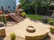 Well-designed outdoor space with brick patio, fire pit, built-in grill, and stairs to backyard deck at 10513 Cardington Ln, Raleigh, NC 27614