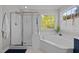 Bright bathroom featuring a glass door shower and soaking tub at 10513 Cardington Ln, Raleigh, NC 27614