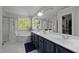 Bathroom featuring double sinks, ample storage, a soaking tub, and a glass door shower at 10513 Cardington Ln, Raleigh, NC 27614